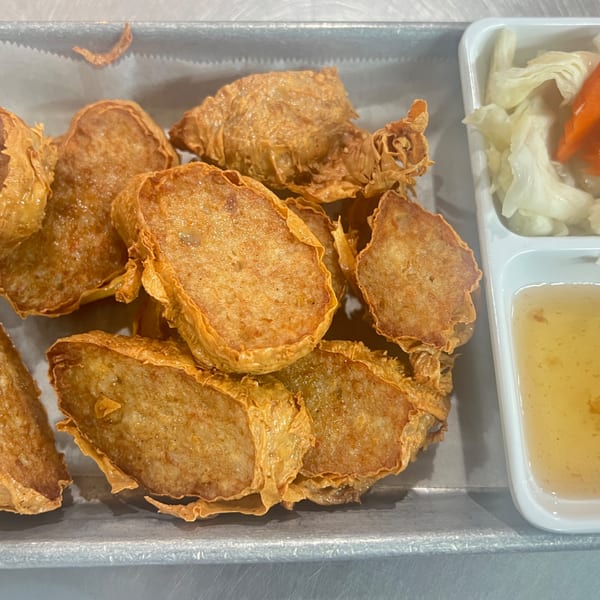 Proud Thai's fried tofu skin rolls, served with pickled vegetables and sweet chili sauce.