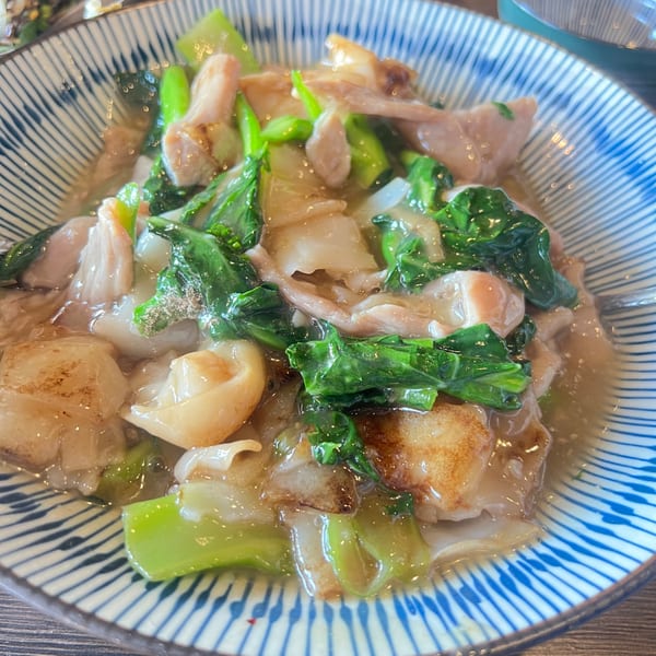 Close-up of Proud Thai's Rad Na, featuring wide rice noodles, pork, and Chinese broccoli in gravy.